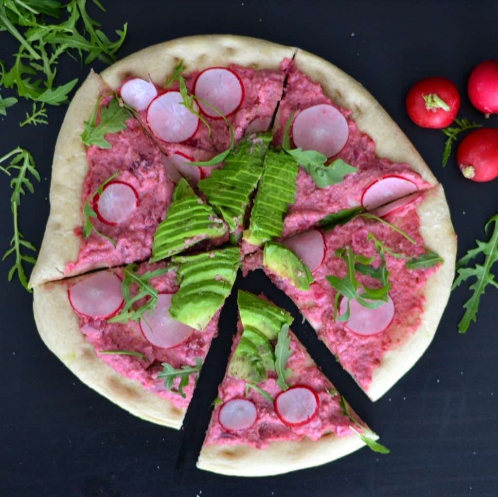 vegan cauliflower pizza with red beet spread and avocado
